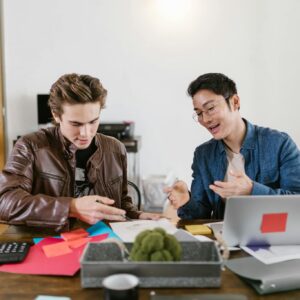 Two business professionals discuss ideas and strategies in an office setting, fostering innovation and teamwork.